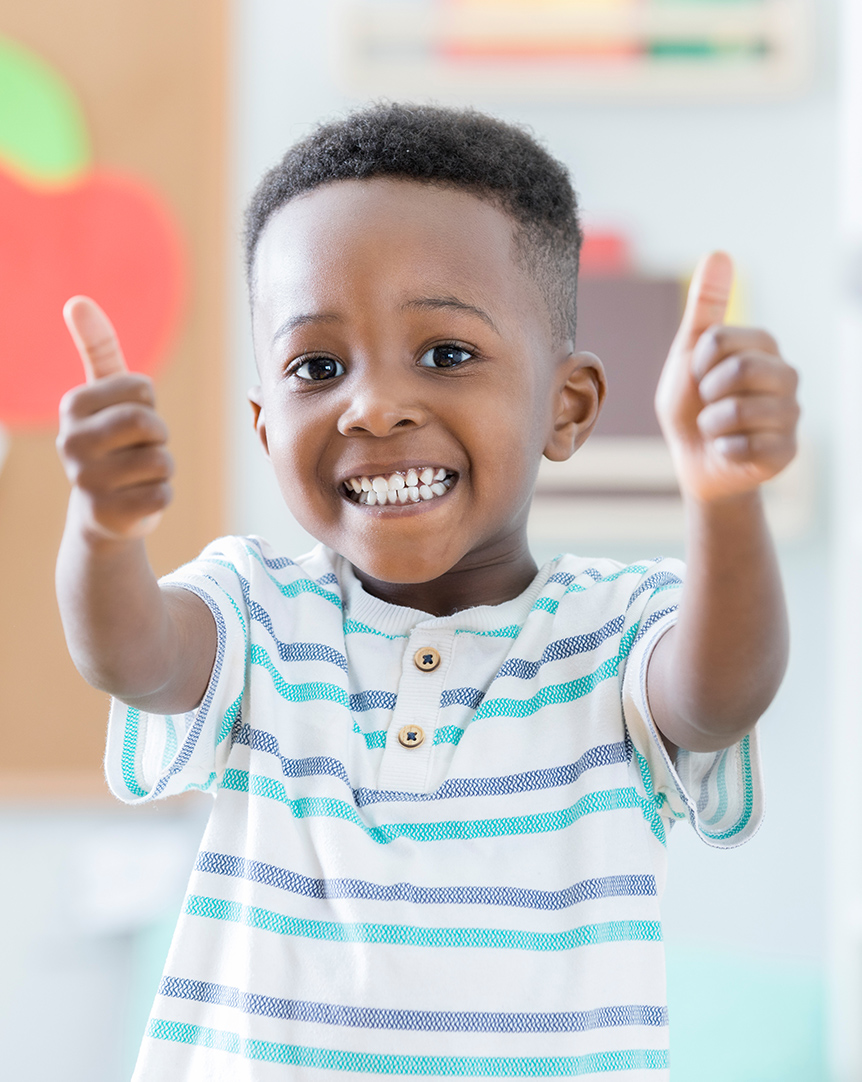 young boy giving two thumbs up