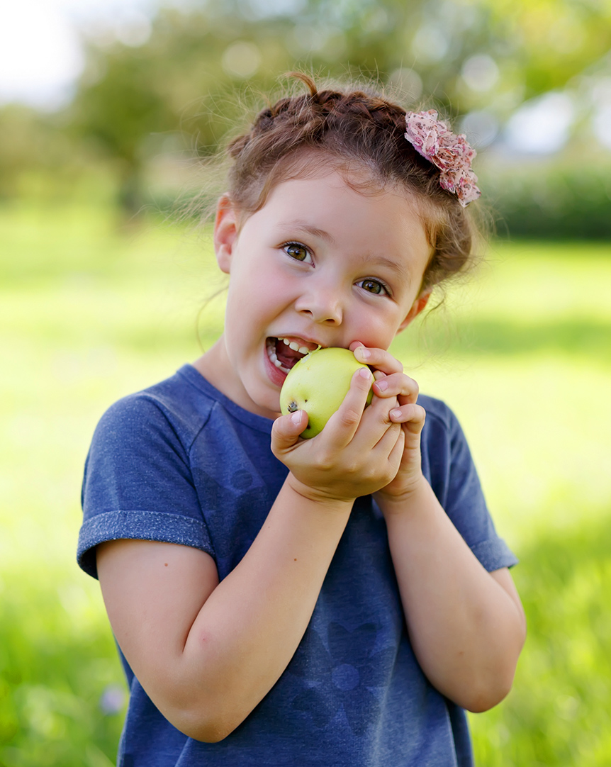 young girl eating an apple